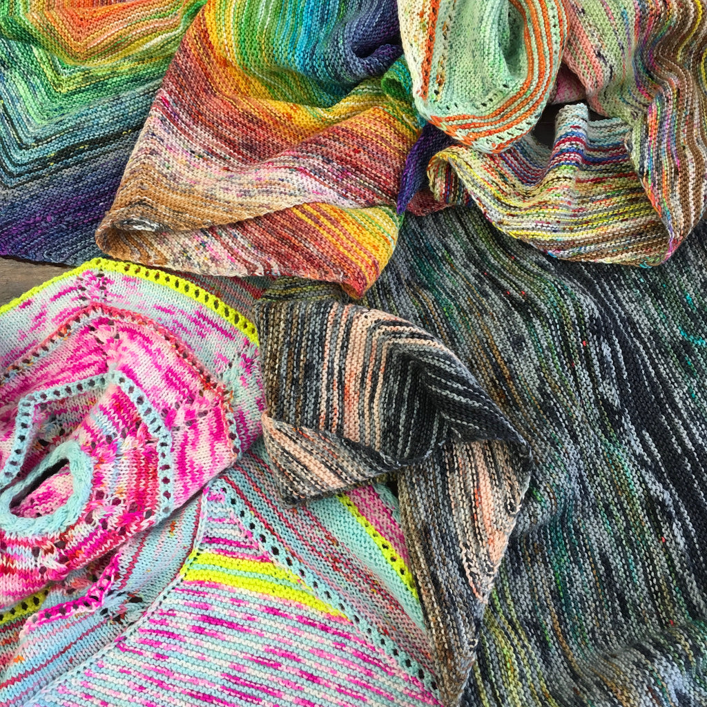 pile of multicoloured shawls knitted in my mama knits hand dyed yarn