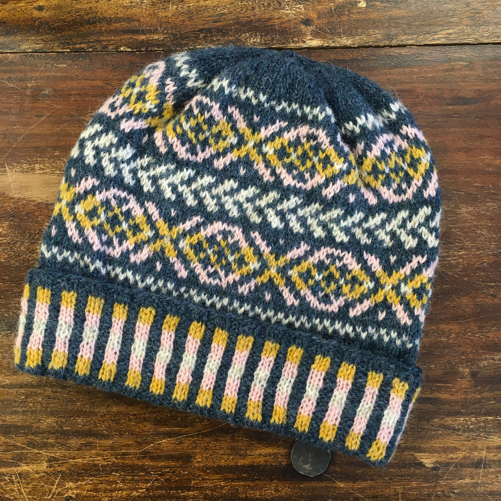 stranded colourwork hat on a dark wood table