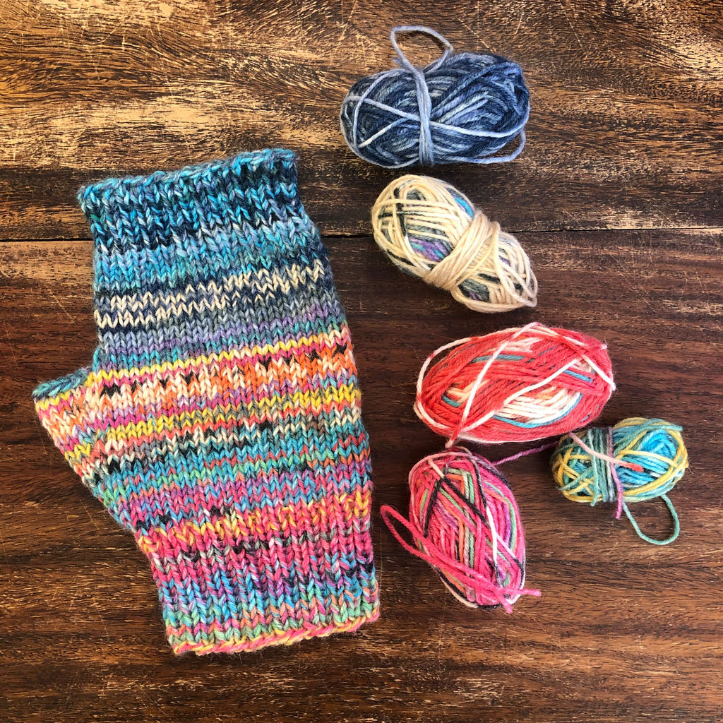 multi coloured fingerless mitts and 5 mini balls of yarn