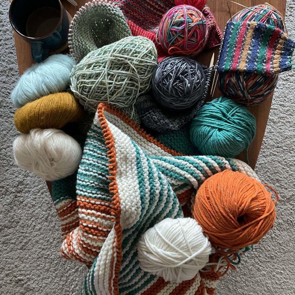coffee table of unfinished knitting projects