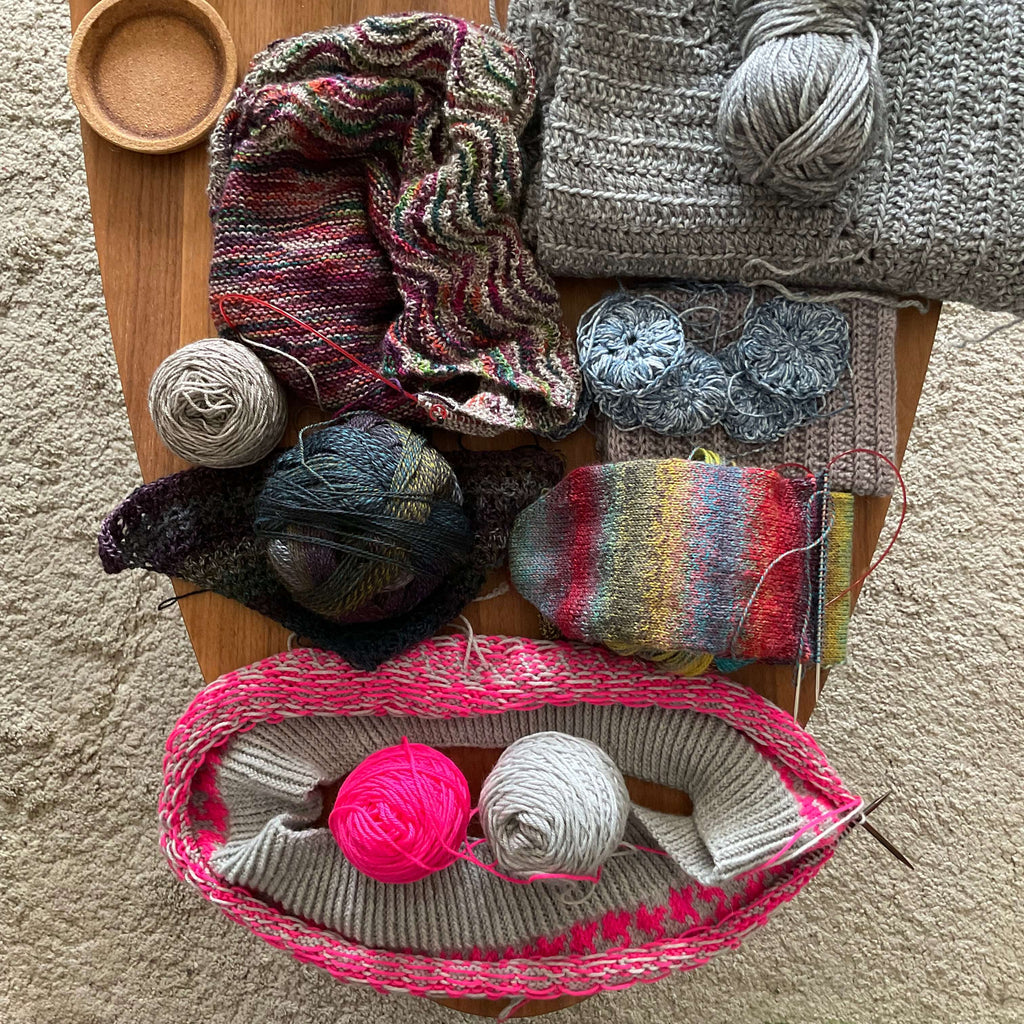 coffee table of unfinished knit and crochet projects