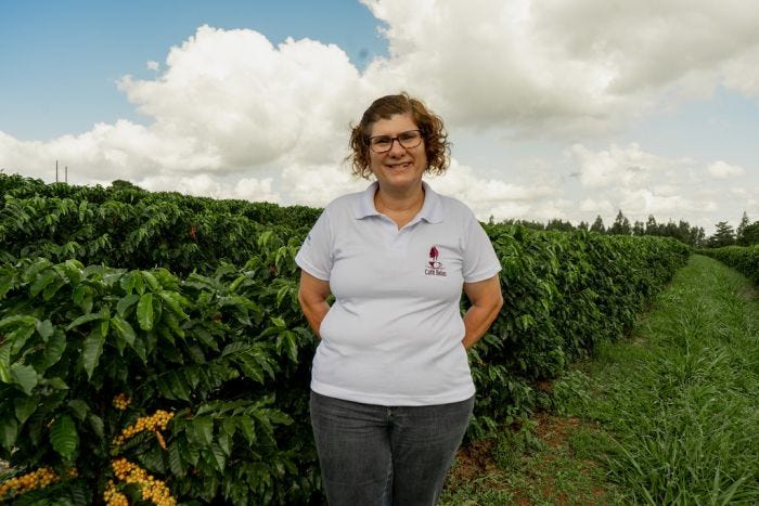 Brazilian Coffee Grower Arabela Pereira Lima proudly standing with her crops.