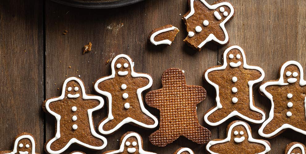 Gingerbread men on a brown table with white frosting.