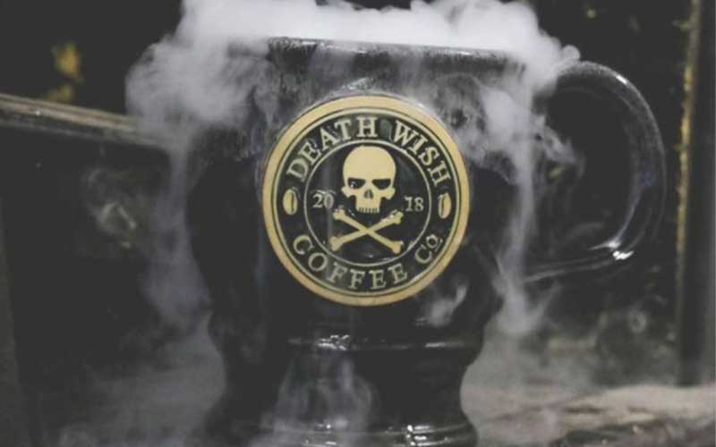 A black Death Wish Coffee mug with smoke coming out the top.