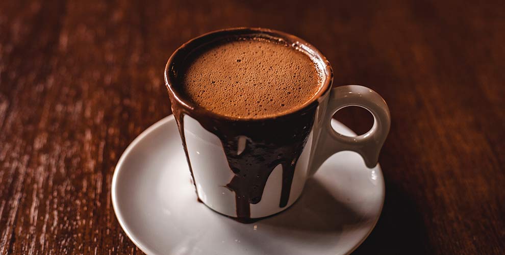 A hot mug full of highly caffeinated mocha coffee.