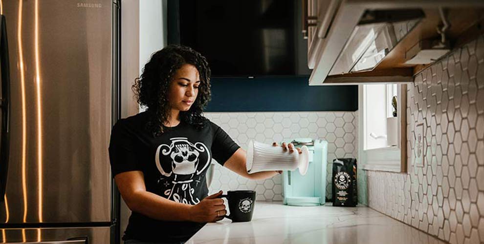 A woman cleaning the kitchen using coffee grounds.