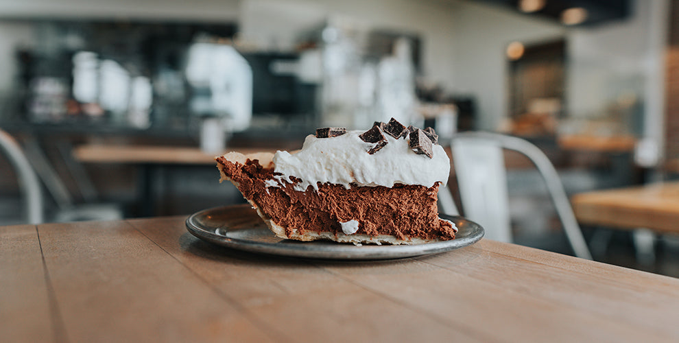A slice of chocolate midnight pie topped with coffee and whipped cream.