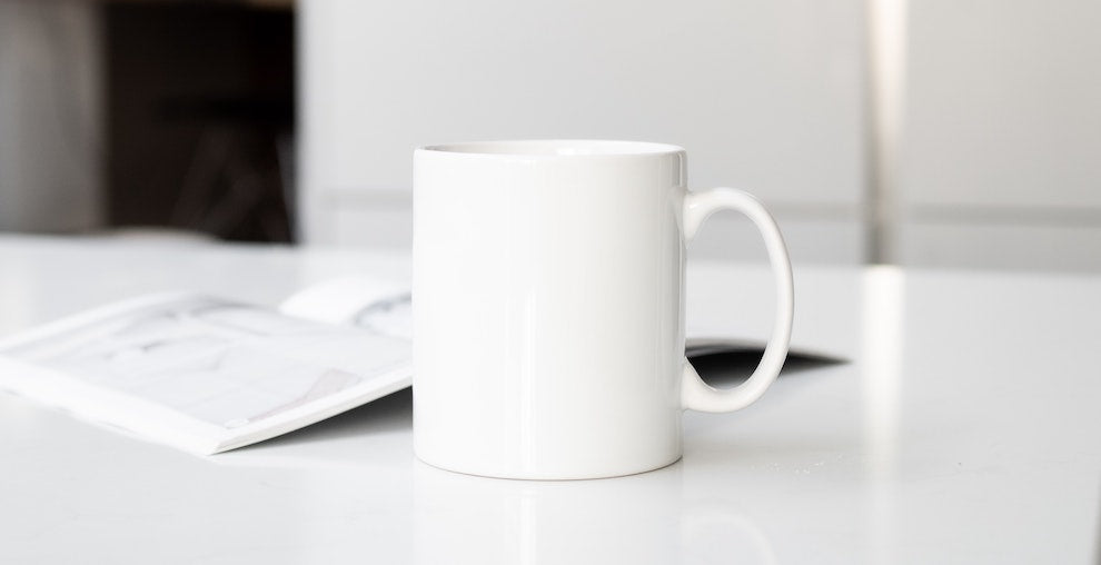 white coffee mug on white counter top