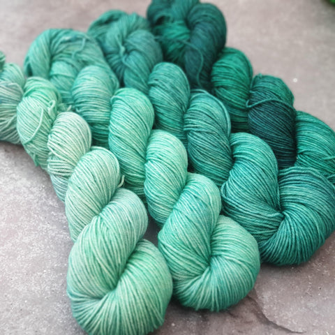 A four-skein fade set going from a light teal shade to a deep, dark teal