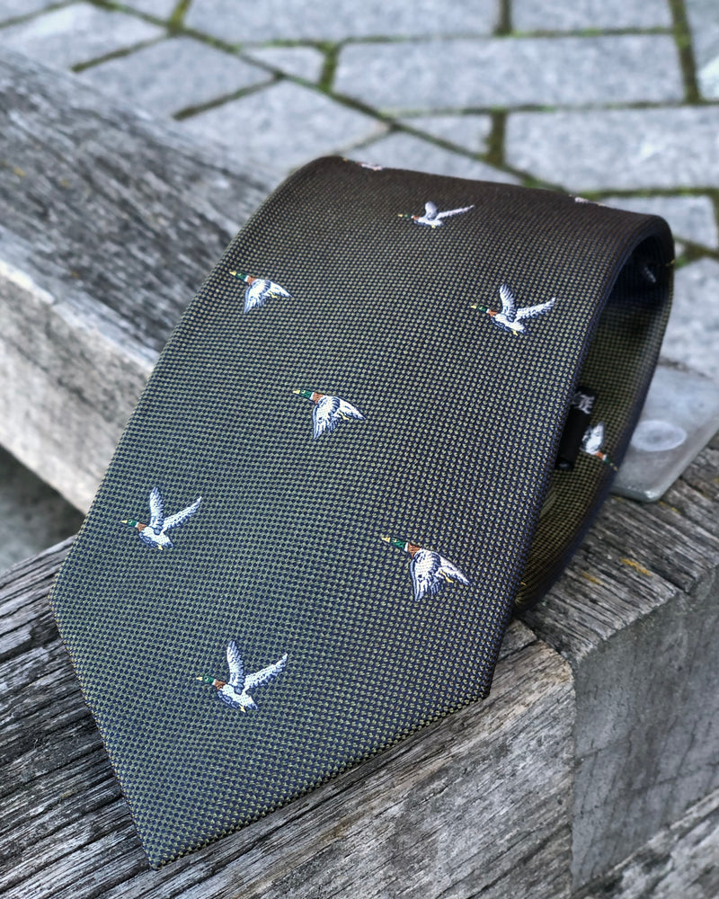 A pure silk tie featuring flying ducks against a grey-green background