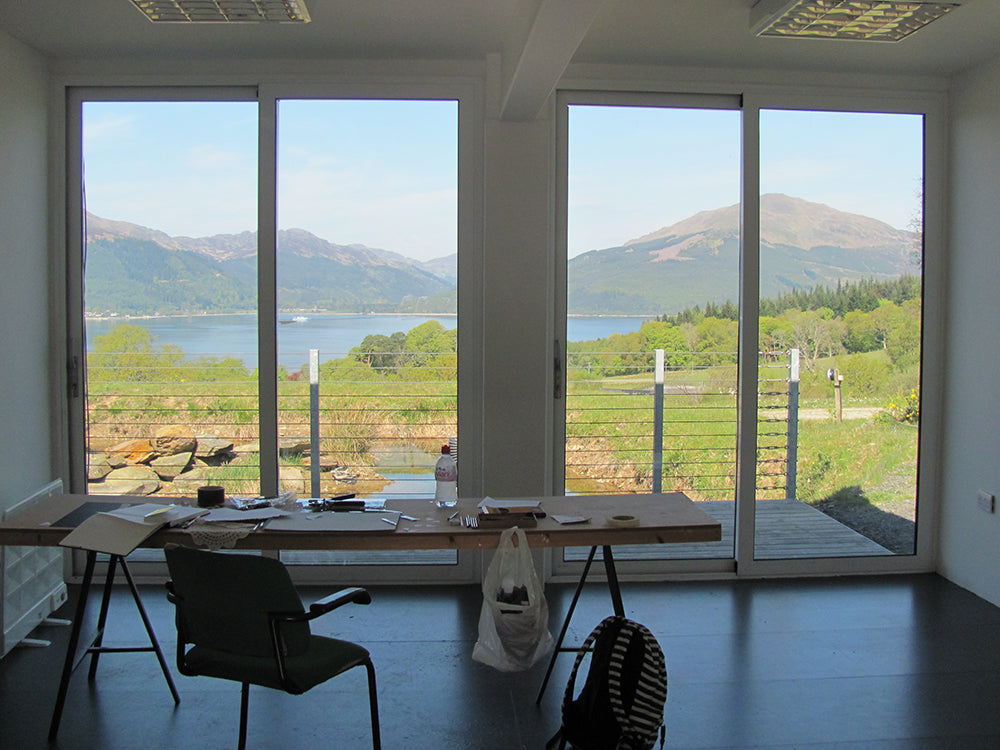 Looking out from the shipping container studio onto hills and the loch