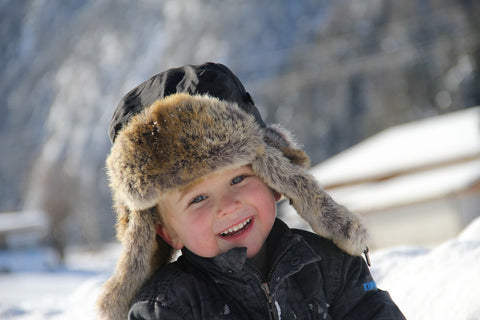 A boy wearing fashionable hat with ear flaps