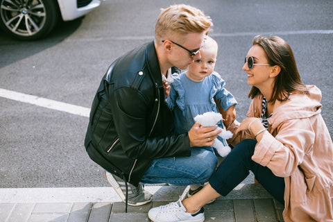  A loving couple sitting on the road with their baby