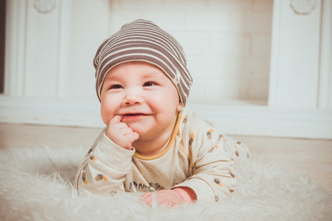 a smiling baby showing fabrics for baby clothes