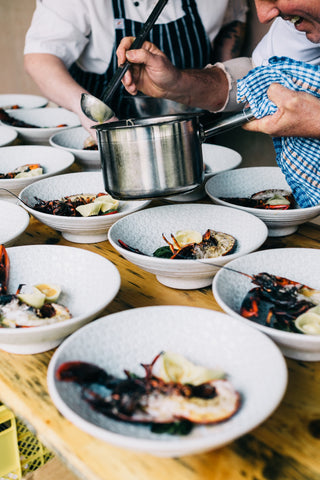 Crop chefs serving lobsters in restaurant