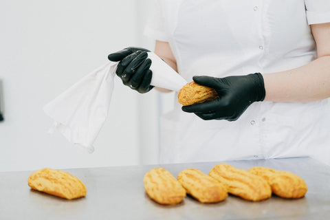 Pastry Chef Putting Frosting on a Bread