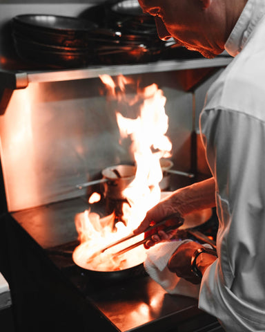 chef cooking a dish using flambe