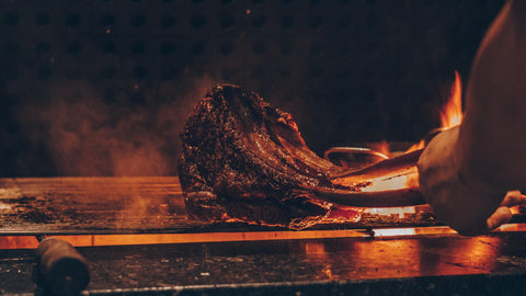 man grilling a tomahawk steak