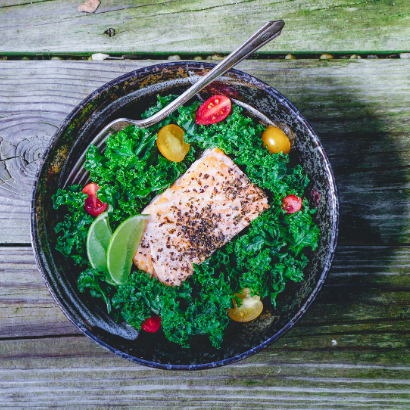 bowl of kale salad with pistachio crusted salmon