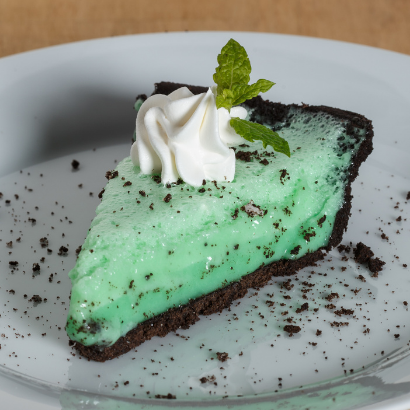 slice of green grasshopper pie with a dollop of whipped cream