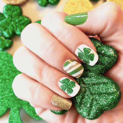 festive st patricks day manicure with glittery stripes and clovers