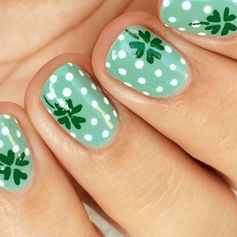 manicure with white polka dots and green shamrocks on mint nail polish