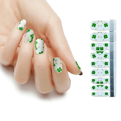 St. Patrick's day manicure with green clovers on white base coat