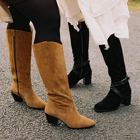 two women wearing wide calf suede heeled boots