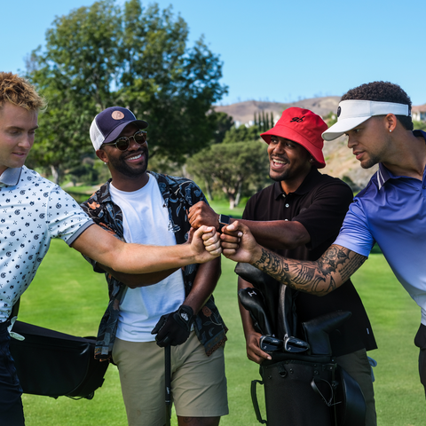 photo of a group of guys fist bumping on the golf course