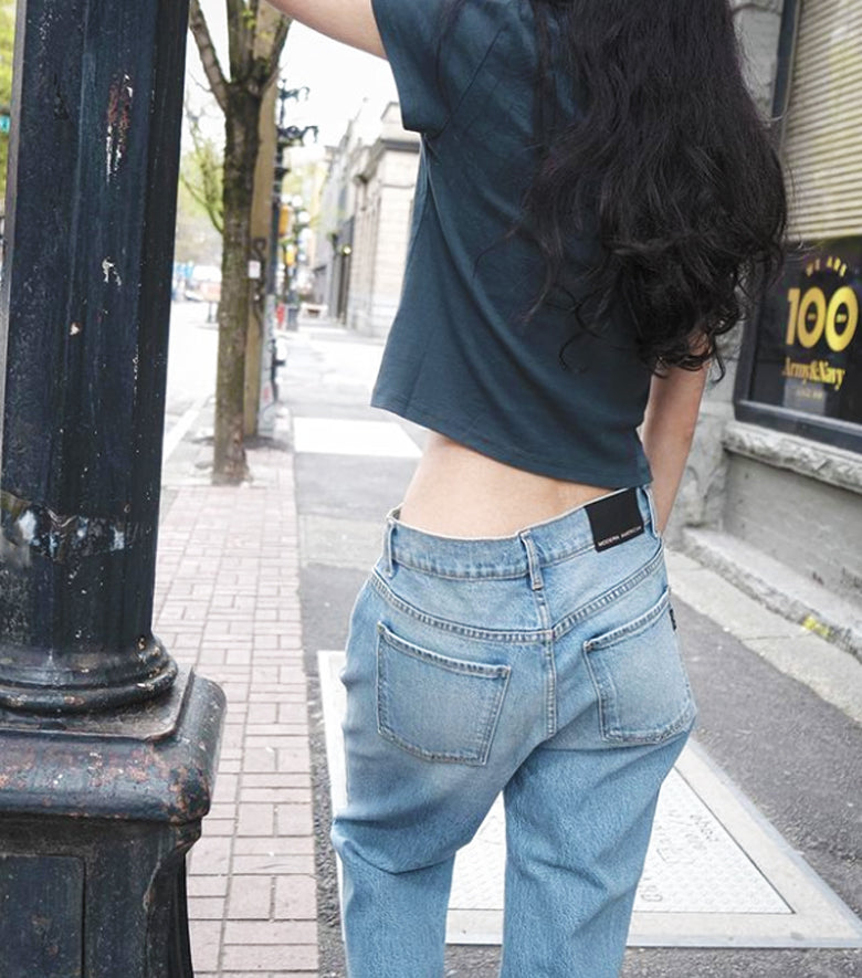 girl from back with a cropped tee and jeans
