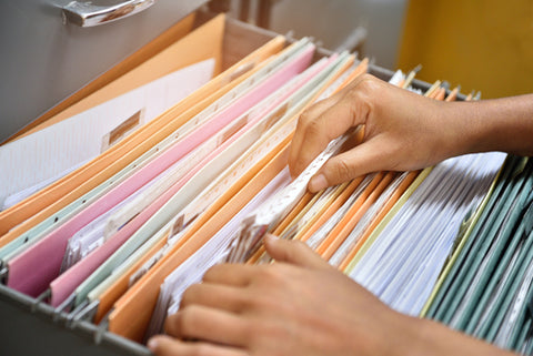 person sifting through filing cabinet