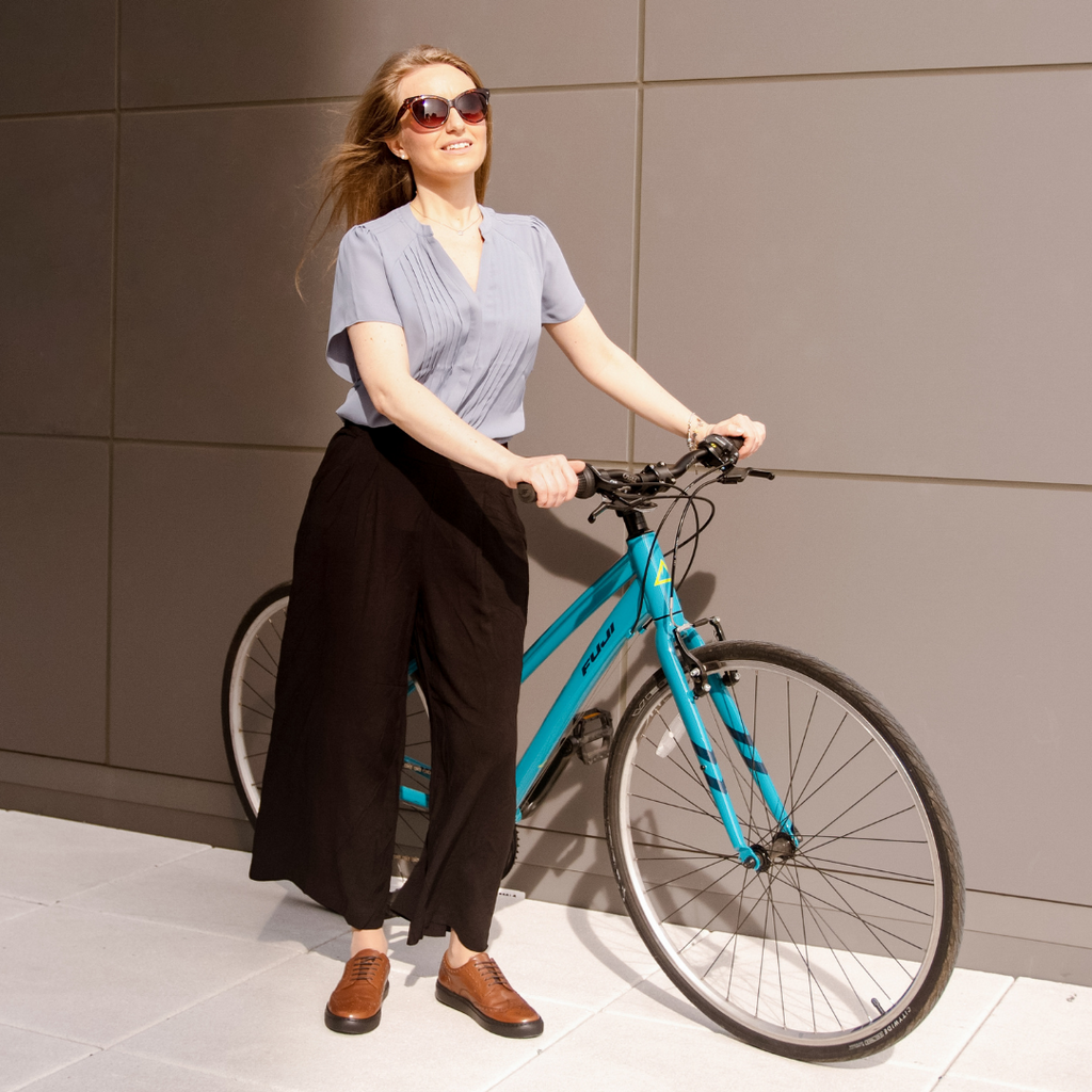 Girl arriving to work with bike wearing dressy sneakers