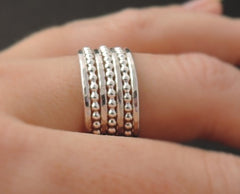 Stack of silver rings on finger