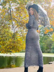 Portrait photograph of person wearing rented stripy knit maxi dress facing left
