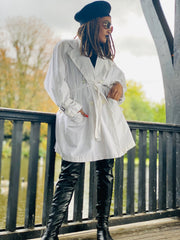Outfit shot of person wearing white cropped trench facing right