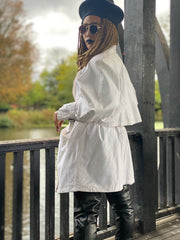 Outfit shot of person wearing white cropped trench coat back to camera