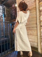 Outfit shot of person wearing beige long skirt and matching flowy top facing away from the camera