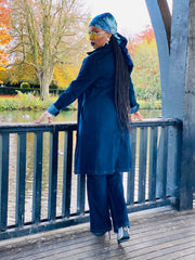 Outfit shot of person wearing denim jacket and headscarf facing away from camera