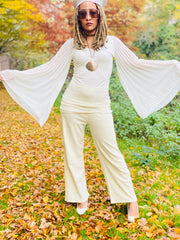 Outfit shot of person wearing white floaty angel wing top facing camera and lifting arms above head