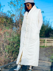 Outfit shot of person wearing white maxi puffer gilet zipped up facing left