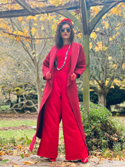 Outfit shot of person wearing long red coat facing forward