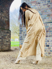 Outfit shot of person wearing golden jacket and trousers with back to camera