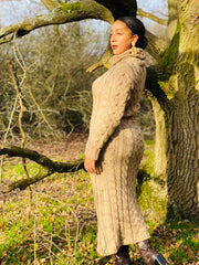 Outfit shot of person wearing beige knitted dress facing left