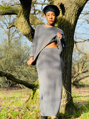 Outfit shot of person wearing matching grey skirt and jumper facing camera