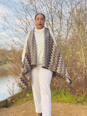 Outfit shot of person wearing zig zag waistcoat and cream trousers and top facing the camera