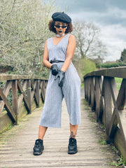 Portrait photo of person wearing rented grey jumpsuit facing camera posing