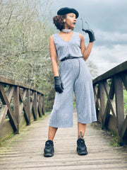 Portrait photo of person wearing rented grey jumpsuit facing camera posing