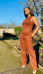Portrait photo of a person wearing rented brown jumpsuit facing left