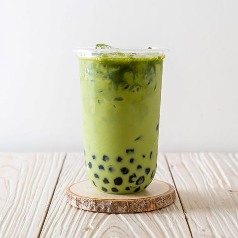 matcha milk tea with tapioca pearls bubble on a wooden coaster