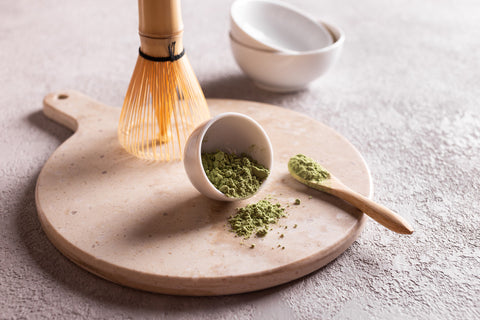 matcha powder with bamboo whisk and spoon